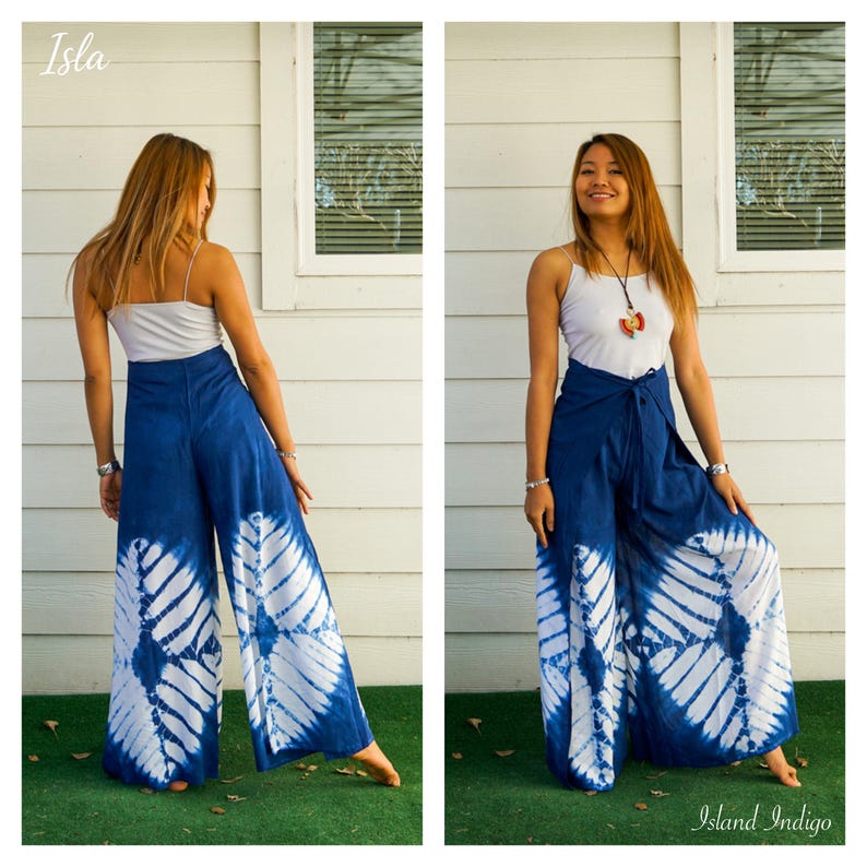 May include: A pair of wide-leg trousers featuring a deep blue and white tie-dye pattern with a diamond-shaped motif. The trousers have a high-waisted design with a tie-front closure. The text Isla and Island Indigo appear in the corners.