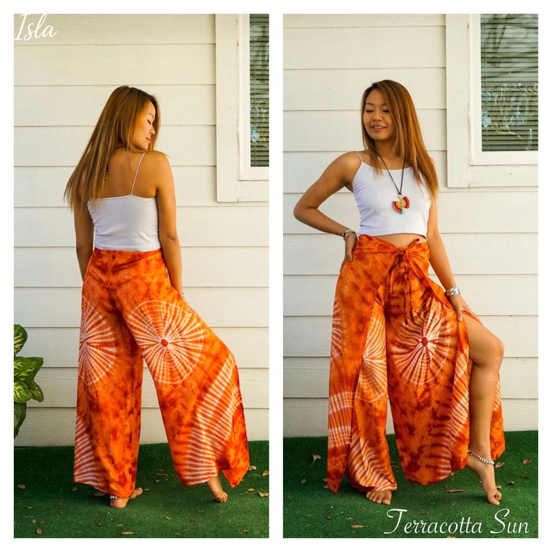 May include: A white spaghetti strap tank top paired with wide-leg orange tie-dye pants featuring a circular sunburst pattern. The pants have a high-waisted tie closure and side slits. The text Isla and Terracotta Sun appear in the corners.