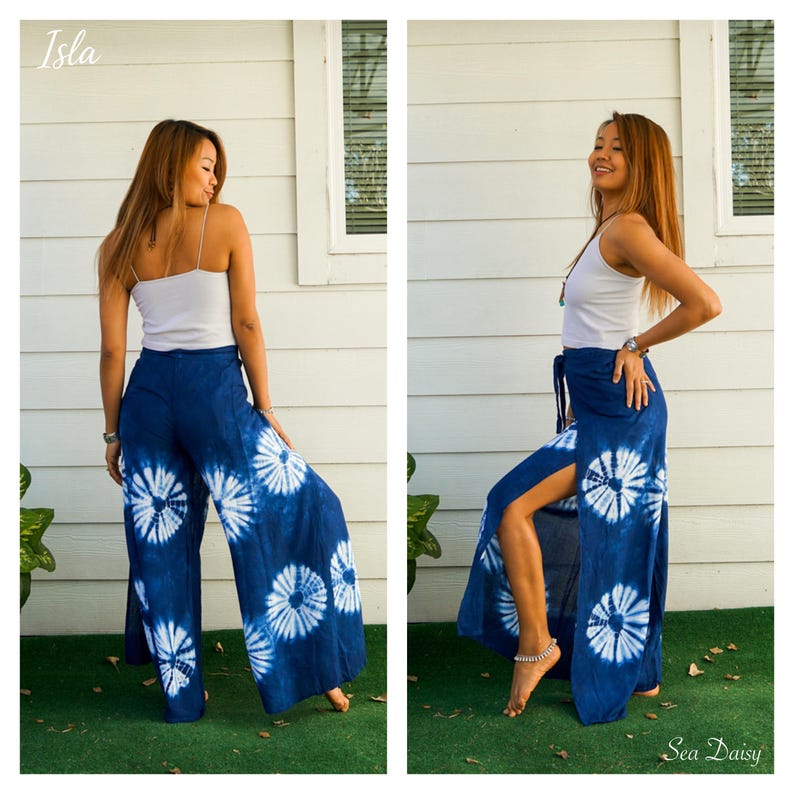 May include: A white spaghetti strap tank top paired with wide-leg pants featuring a blue and white tie-dye sunburst pattern. The pants have high side slits that reveal the legs, and the text Isla and Sea Daisy appear in the corners of the image.