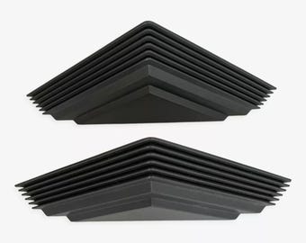 May include: Two black, geometric, corner-shaped architectural elements. Each piece has a layered, stepped design, with a triangular base and a series of horizontal ridges. The pieces are displayed against a plain white background.