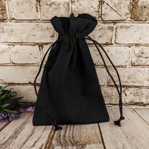 Puede incluir: Una bolsa negra de tela con cord&oacute;n de ajuste. La bolsa est&aacute; vac&iacute;a y tiene un dise&ntilde;o sencillo.