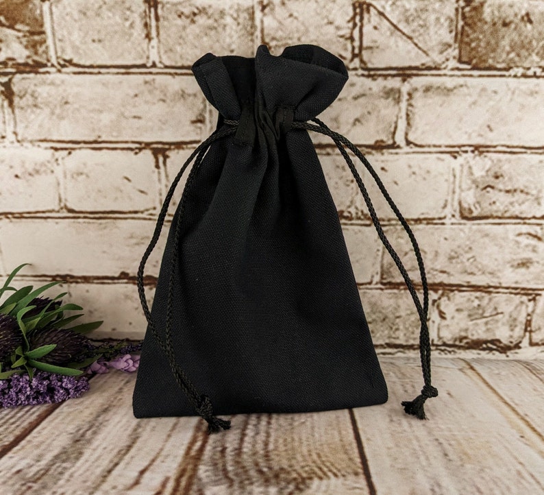 Puede incluir: Una bolsa negra de tela con cord&oacute;n de ajuste. La bolsa est&aacute; vac&iacute;a y tiene un dise&ntilde;o sencillo.