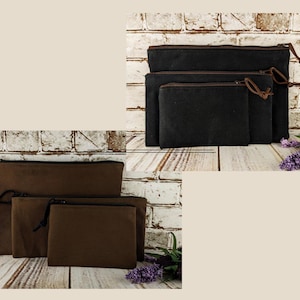 May include: Two sets of three rectangular zippered pouches in black and brown. Each set features three different sizes, all made of a solid-colored fabric with matching zippers and simple pull tabs, arranged in a nested formation.