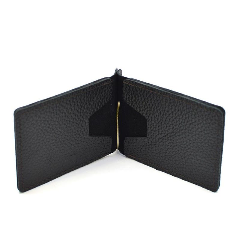 Puede incluir: Una cartera con clip para billetes de cuero texturizado en color marr&oacute;n oscuro, con un mecanismo central de clip met&aacute;lico en tono dorado. La cartera est&aacute; abierta, mostrando dos ranuras interiores para tarjetas con cortes angulares a cada lado.