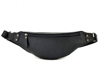 May include: Black leather fanny pack with a zippered main compartment and adjustable strap. The bag features a sleek, minimalist design with a small zipper pull and metal hardware. Perfect for carrying essentials while keeping hands free.