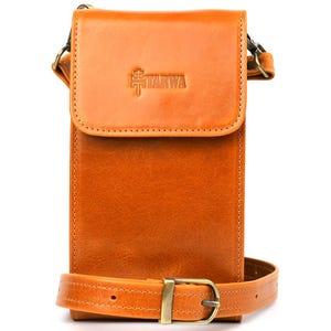 Puede incluir: Bolso bandolera rectangular de cuero color marrón claro, con cierre de solapa y correa ajustable. El bolso tiene un cierre de hebilla y el texto "TARWA" en relieve en la solapa. Diseñado para llevar al hombro.