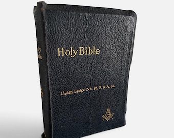 May include: A black, textured, hardcover Holy Bible with gold lettering on the front cover. The text reads Holy Bible and Union Lodge No. 95, F. & A. M. A gold Masonic square and compass symbol is printed near the bottom right corner of the cover.