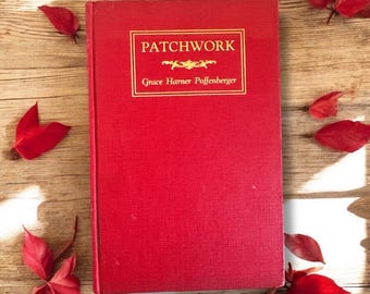 May include: A red hardcover book titled "Patchwork" by Grace Harner Poffenberger, with gold lettering. The book is surrounded by red leaves on a wooden surface, creating a seasonal autumn theme.