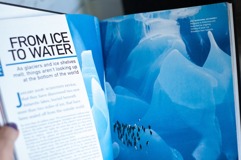 May include: Open book with the title "FROM ICE TO WATER" and text about melting glaciers and ice shelves. The right page shows a blue image of ice formations and penguins. The text "NOT MARCHING ANYMORE? Penguins in Antarctica are imperiled as ongoing melting of polar ice threatens their habitats."