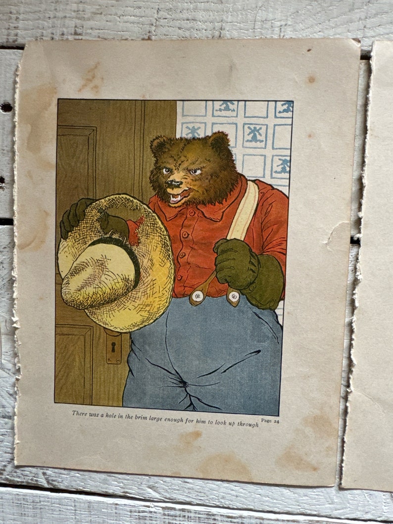 May include: A brown bear wearing a red shirt, blue pants, and a straw hat with a hole in the brim. The bear is looking through the hole in the hat. The text "There was a hole in the brim large enough for him to look up through. Page 24" is printed below the image.