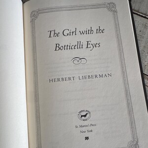 May include: Open book page with the title "The Girl with the Botticelli Eyes" by Herbert Lieberman. The text is in black font, framed by a decorative border. The St. Martin's Press logo is visible.