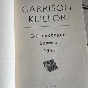 May include: Open book page with the title "Garrison Keillor" above "Lake Wobegon Summer 1956." A small illustration of a vintage typewriter is below the text. The publisher's name, "VIKING," is at the bottom.