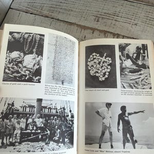 May include: A vintage book featuring black and white photographs. The images depict gold chains, a silver bar, a coral and gold rosary, and a group of people on a ship. Captions include "Chains of gold and a gold button" and "Gene Lyon and "Moe" Molinar, aboard Virgilona."