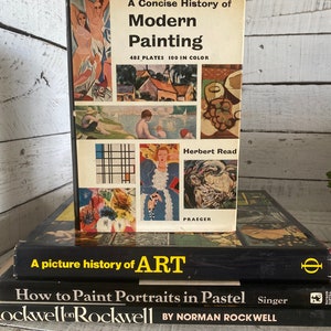 K&ouml;nnte beinhalten: Ein Stapel von drei alten gebundenen B&uuml;chern &uuml;ber Kunst. Das oberste Buch tr&auml;gt den Titel "A Concise History of Modern Painting" mit 485 Tafeln und 100 in Farbe. Das zweite Buch tr&auml;gt den Titel "A picture history of ART". Das dritte Buch tr&auml;gt den Titel "How to Paint Portraits in Pastel" von Norman Rockwell.