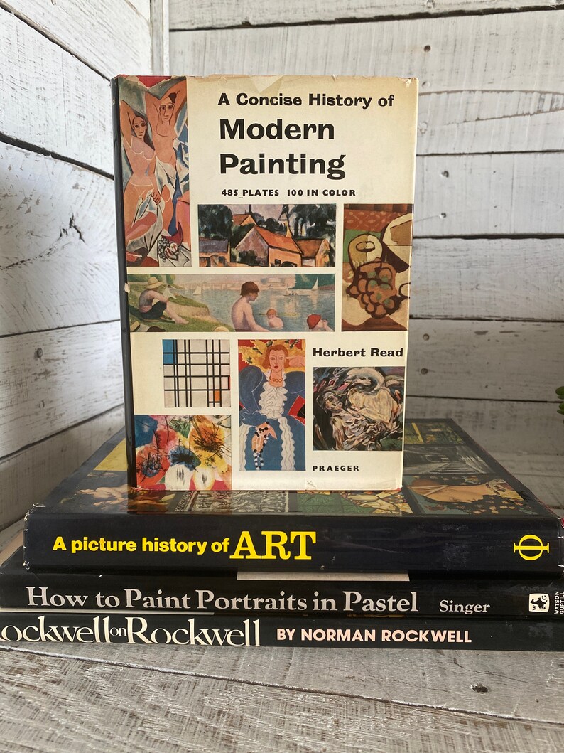 K&ouml;nnte beinhalten: Ein Stapel von drei alten gebundenen B&uuml;chern &uuml;ber Kunst. Das oberste Buch tr&auml;gt den Titel "A Concise History of Modern Painting" mit 485 Tafeln und 100 in Farbe. Das zweite Buch tr&auml;gt den Titel "A picture history of ART". Das dritte Buch tr&auml;gt den Titel "How to Paint Portraits in Pastel" von Norman Rockwell.