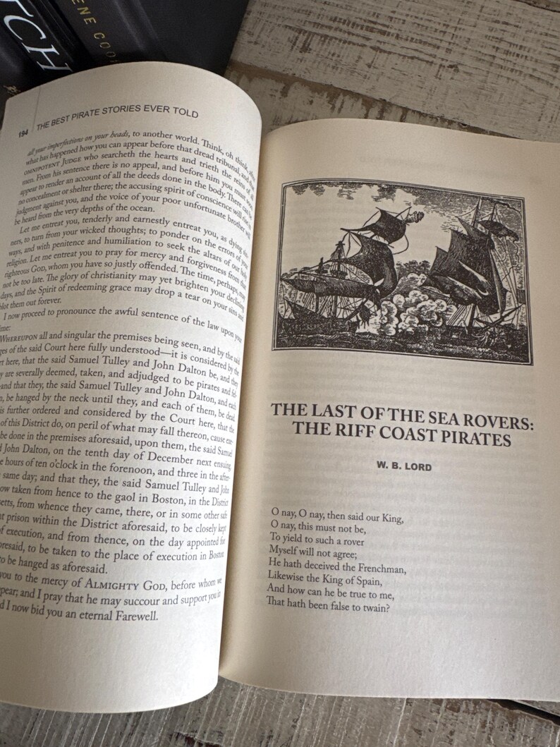 Pu&ograve; includere: Libro aperto con testo e un'illustrazione di velieri. Il titolo recita "The Last of the Sea Rovers: The Riff Coast Pirates" di W.B. Lord. La pagina contiene anche una poesia.