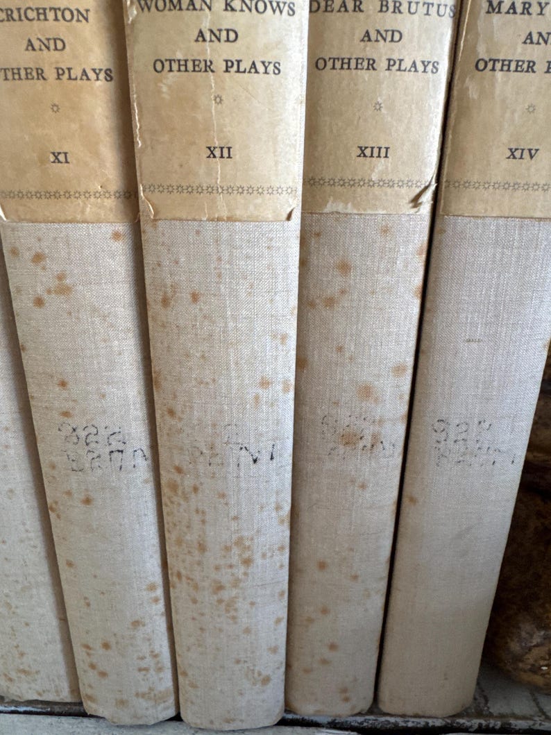Puede incluir: Primer plano de una colecci&oacute;n de libros antiguos. Las lomos son de color blanquecino con t&iacute;tulos y n&uacute;meros impresos en negro. Los libros muestran signos de edad con decoloraci&oacute;n y manchas. Los t&iacute;tulos incluyen "Crichton and Other Plays" y "Woman Knows and Other Plays".