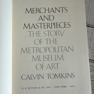 May include: An open book page displaying the title "Merchants and Masterpieces" and the subtitle "The Story of the Metropolitan Museum of Art" by Calvin Tomkins. Published in 1970 by E.P. Dutton & Co., Inc., New York.