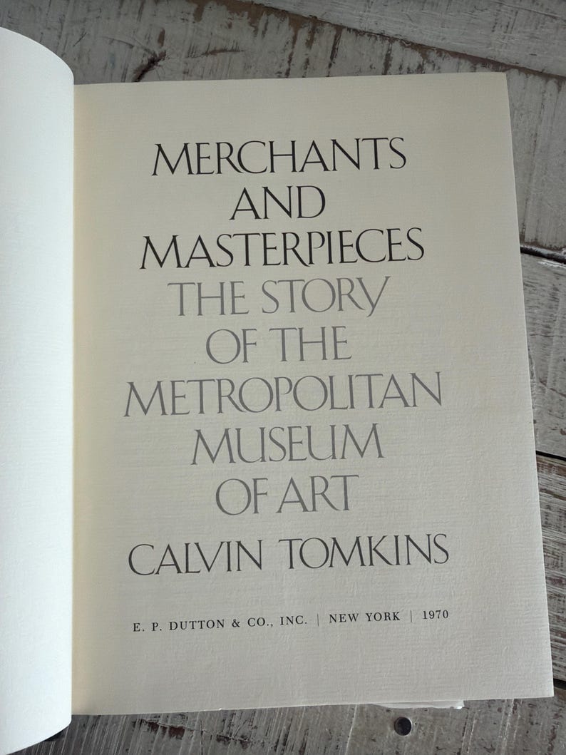May include: An open book page displaying the title "Merchants and Masterpieces" and the subtitle "The Story of the Metropolitan Museum of Art" by Calvin Tomkins. Published in 1970 by E.P. Dutton & Co., Inc., New York.