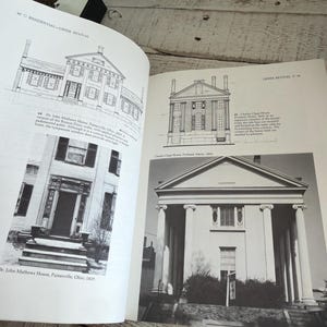 May include: An open book displaying black and white architectural illustrations and photographs of Greek Revival houses, including the Dr. John Mathews House and the Charles Clapp House, with descriptive text detailing the building designs.