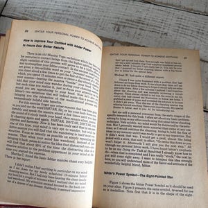 Puede incluir: Libro abierto con texto sobre Ishtar y t&eacute;cnicas de meditaci&oacute;n. Las p&aacute;ginas tienen un aspecto envejecido. El libro est&aacute; sobre una superficie de madera.