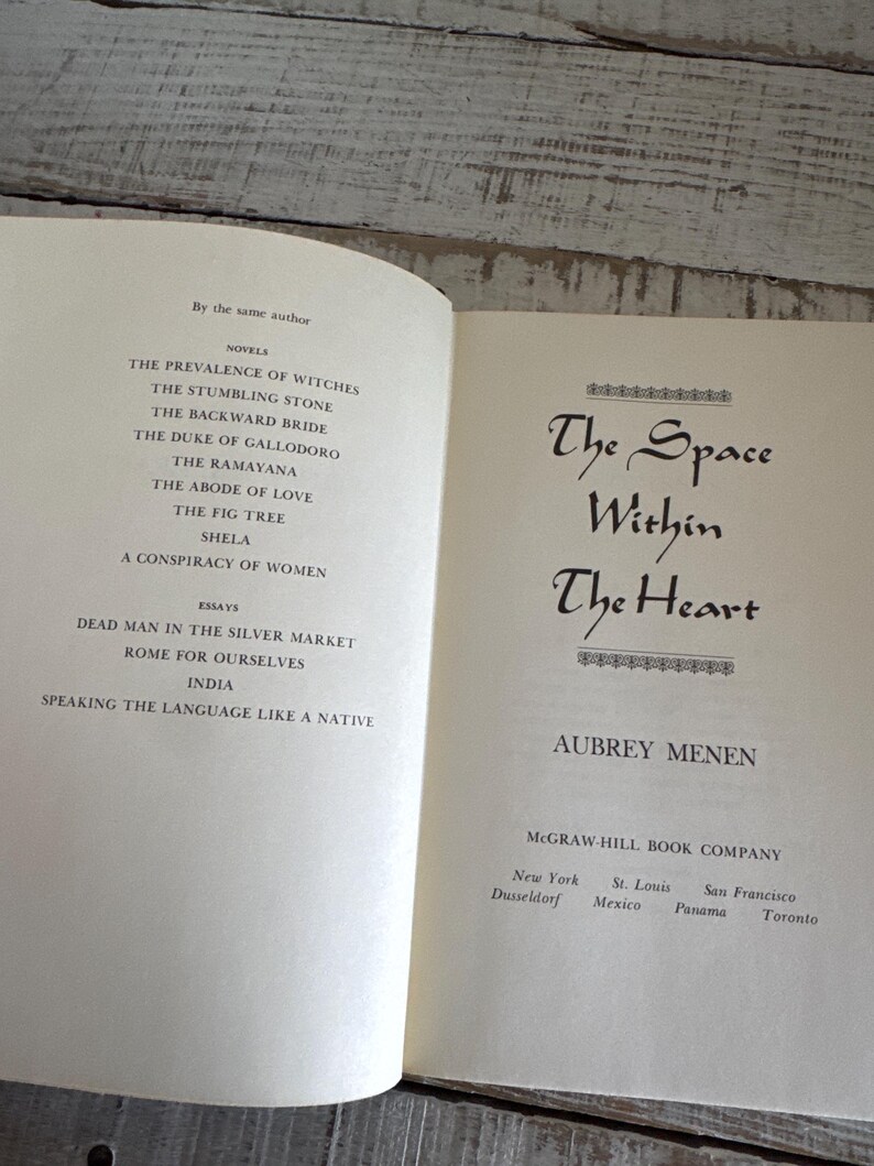 May include: A book titled "The Space Within The Heart" by Aubrey Menen. The book cover is white with black text. The book is published by McGraw-Hill Book Company.