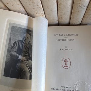 Puede incluir: Un libro antiguo abierto, titulado "My Lady Nicotine" de J.M. Barrie. Muestra un retrato en blanco y negro de un hombre. Publicado por Charles Scribner's Sons, Nueva York, MCMXXIX. La p&aacute;gina del t&iacute;tulo es visible.