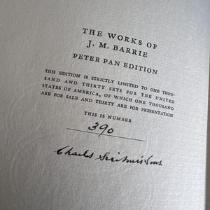 Puede incluir: Primer plano de una p&aacute;gina de "The Works of J.M. Barrie, Peter Pan Edition". El texto incluye la cantidad limitada de la edici&oacute;n y el n&uacute;mero 390. Hay una firma debajo del n&uacute;mero.