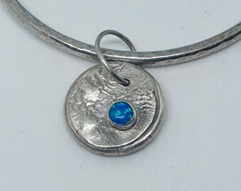 sterling silver handmade hammered bangle with synthetic topaz charm