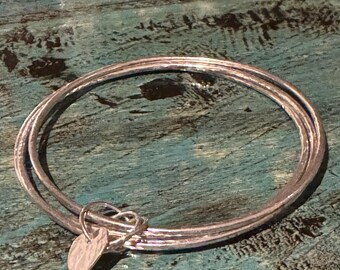 Handmade trio of sterling silver bangles with a hammered little loveheart charm!