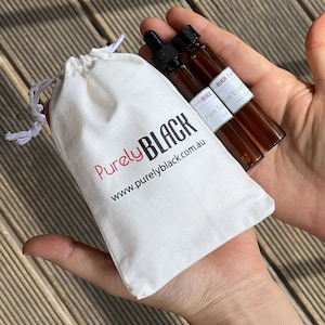 May include: Two small brown glass bottles with droppers, labelled "Purely BLACK Pure Essential Oils 10ml", in a white drawstring bag with the text "Purely BLACK www.purelyblack.com.au"