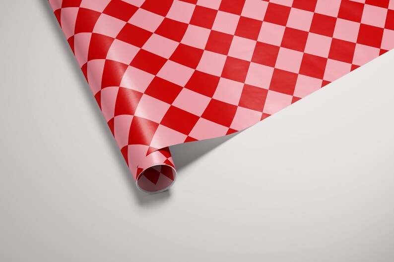 May include: A roll of red and pink checkered wrapping paper is partially unrolled, revealing the pattern. The paper is curled at the edge, creating a three-dimensional effect.