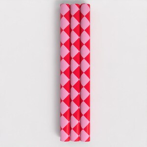 May include: Three red and pink striped wrapping paper rolls. The paper has a checkered pattern.