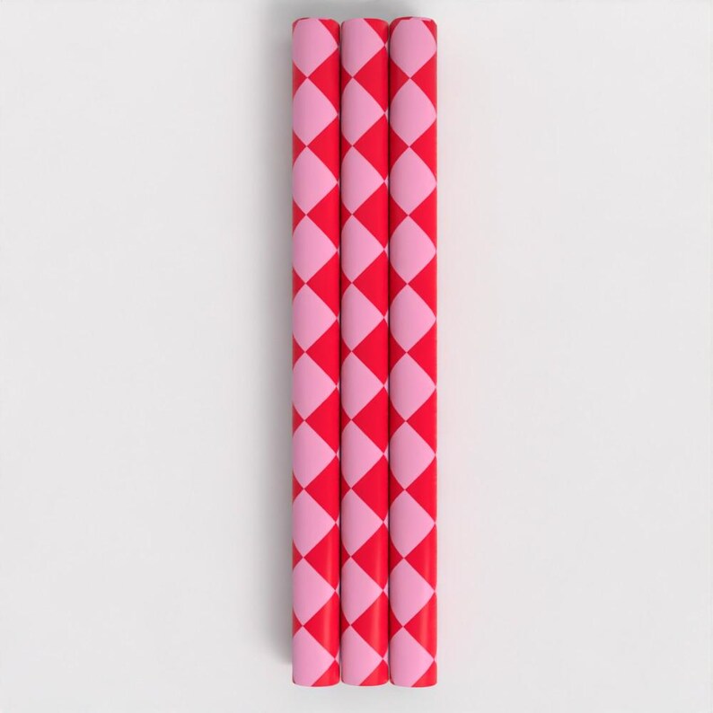 May include: Three red and pink striped wrapping paper rolls. The paper has a checkered pattern.