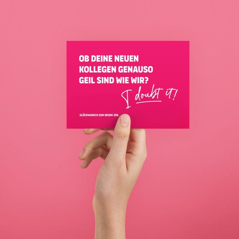 May include: A magenta card with white text and the handwritten phrase "I doubt it!" is held against a pink background. The card's text reads, "OB DEINE NEUEN KOLLEGEN GENAUSO GEIL SIND WIE WIR? GL&Uuml;CKWUNSCH ZUM NEUEN JOB."