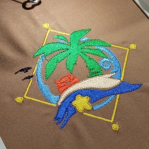 May include: Embroidered design featuring a palm tree, a blue wave, a yellow star, and a red and orange cat. The design is surrounded by a yellow square frame.