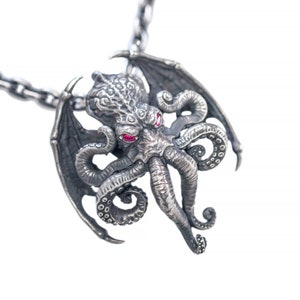 Peut inclure: Un collier pendentif argenté avec un design détaillé de Cthulhu. Le pendentif a des yeux en pierres précieuses rouges, des ailes et des tentacules. La chaîne du collier est également argentée et a un design à maillons. Un bijou unique.