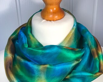 Delicate silk scarf ('slight second') is hand painted with vibrant silk dyes on a stretcher frame and then steam set.