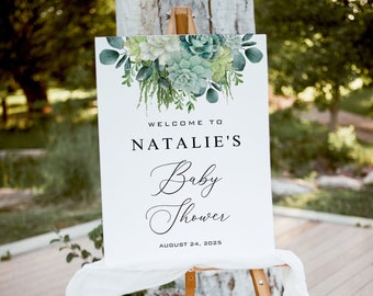May include: White welcome sign with green watercolor succulents and greenery. The sign reads "Welcome to Natalie's Baby Shower August 24, 2025".