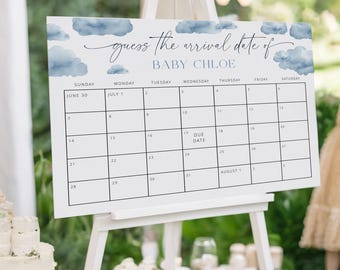 Könnte beinhalten: Ein weißer Staffelei mit einem blauen und weißen Babyparty-Schild, auf dem "erraten Sie das Ankunftsdatum von BABY CHLOE" steht. Das Schild hat einen Kalender mit den Monaten Juni und Juli, wobei das Fälligkeitstermin auf den 17. Juli markiert ist.