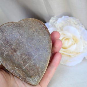 Puede incluir: Un plato de piedra en forma de coraz&oacute;n con una superficie rugosa de color marr&oacute;n. El plato est&aacute; hecho de piedra natural y tiene un aspecto r&uacute;stico y vintage.