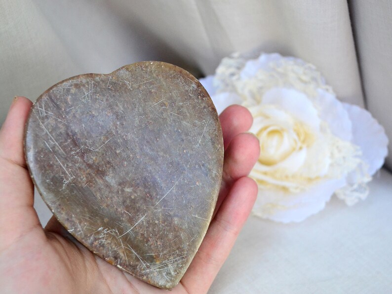 Puede incluir: Un plato de piedra en forma de coraz&oacute;n con una superficie rugosa de color marr&oacute;n. El plato est&aacute; hecho de piedra natural y tiene un aspecto r&uacute;stico y vintage.