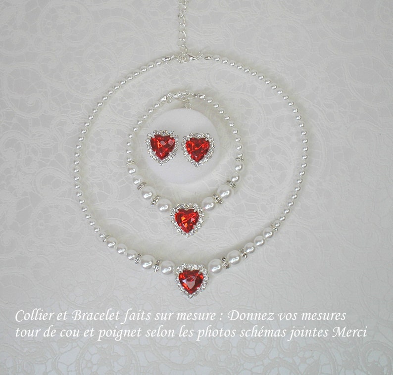 May include: A set of red heart-shaped jewelry with pearl necklaces and earrings. The necklace is a double strand of pearls with a large red heart pendant. The bracelet is a single strand of pearls with a smaller red heart pendant. The earrings are small red heart studs.