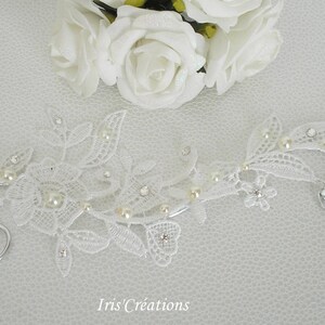 May include: White lace ear cuff with pearl accents and a silver wire design. The ear cuff is delicate and feminine, perfect for a wedding or special occasion.