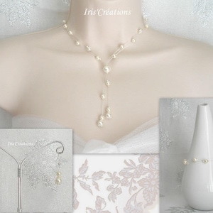 May include: A pearl necklace, earrings, and bracelet set displayed on a mannequin and a white vase. The necklace features a delicate design with a cascade of pearls. The earrings and bracelet also feature pearls. The background is a soft, floral pattern.