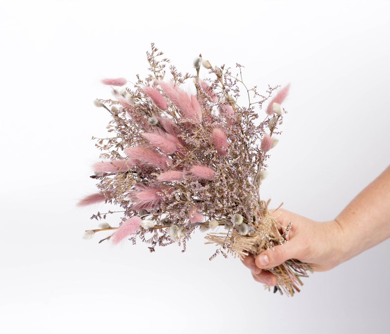 May include: A bouquet of dried flowers with pink bunny tails and purple sprigs tied with twine.