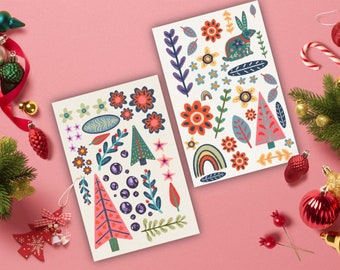 Può includere: Due fogli di carta bianca con illustrazioni colorate di fiori, alberi, arcobaleni e un coniglio. Le illustrazioni sono in stile folk.