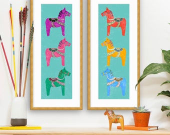 Può includere: Due stampe incorniciate di colorati cavalli svedesi Dala su uno sfondo turchese. I cavalli sono disposti verticalmente in fila, con ogni cavallo di un colore diverso: rosa, verde, blu, arancione, rosso e giallo.