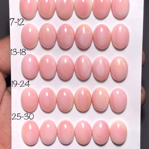 Puede incluir: Treinta gemas ovaladas de color rosa pálido dispuestas en filas sobre una tarjeta blanca. Las gemas están numeradas y miden 10 x 14 mm. La tarjeta también tiene el texto "30 pcs."