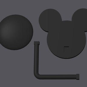 Puede incluir: Soporte en forma de cabeza de Mickey Mouse en blanco y negro con una base redonda y un brazo de metal negro.